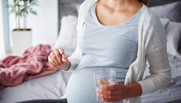 pregnant woman holding a glass of water