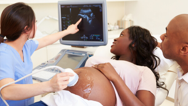 a doctor showing a pregnant woman photos from her sonogram