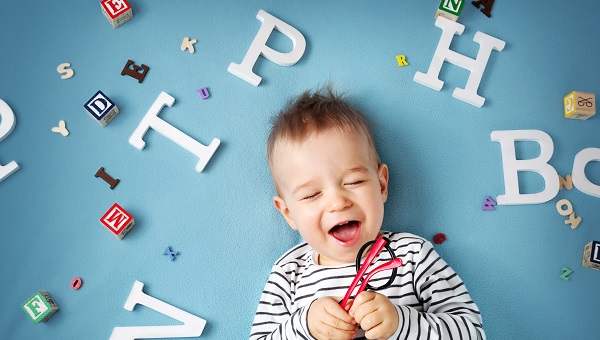happy baby surrounded by white letters on blue background