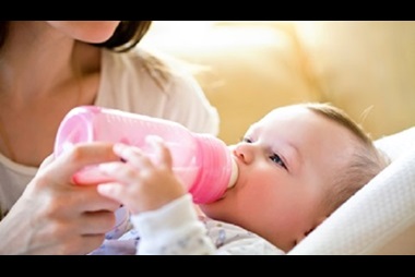happy mother feeds her baby with a bottle