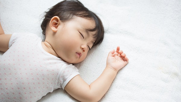 sleeping asian baby on a white pillow