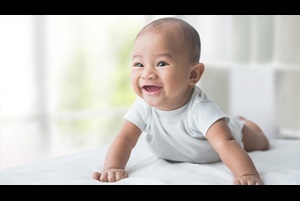 smiling happy baby while doing tummy time at home