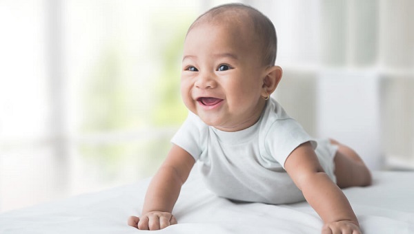 smiling happy baby while tummy time at home