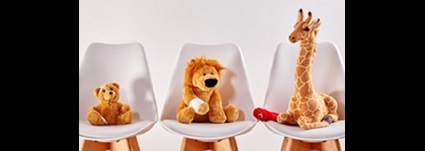 Three cute stuffed animal toys on chairs in the waiting room