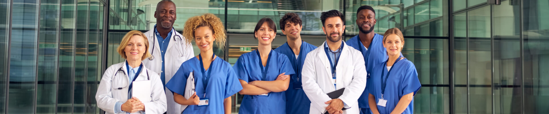 team of health care professionals outside of hospital posing for a photo