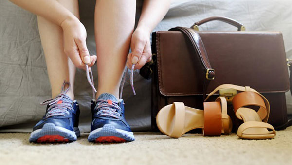A woman is tying the laces of her running shoes.