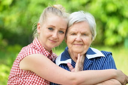 A granddaughter hugs her grandmother.