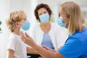 A boy is getting a checkup and vaccination during a visit to his pediatrician's office.