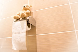 teddy bear sitting on top of toilet paper roll