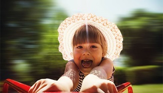 A little girl is riding a merry-go-round.
