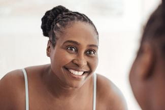 African-american woman looking in the mirror