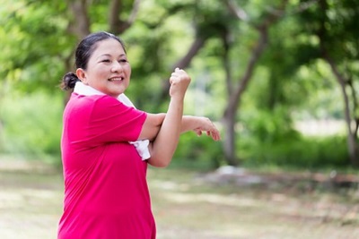 Woman in a pink shirt stretching during her workout