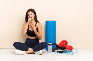 woman coughing next to workout gear