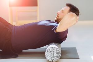 young man using a foam roller