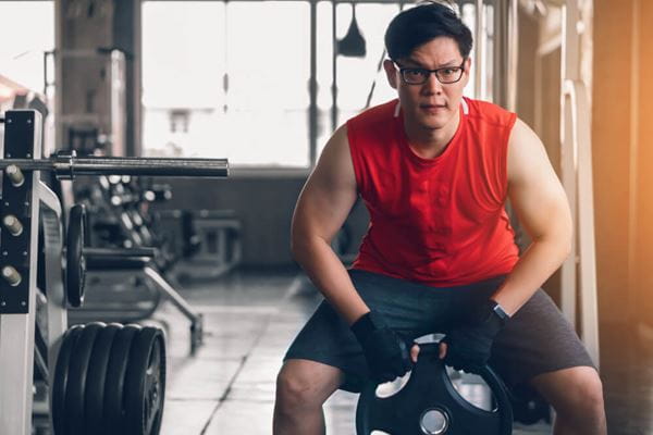 male performing a squat with free weight