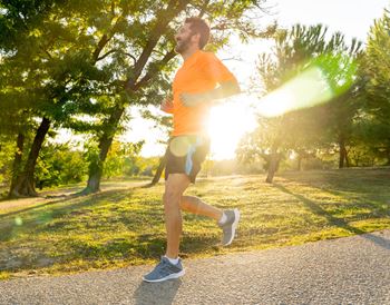 man running outside in orange workout shirt