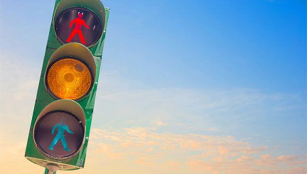 photo of a stop light in front of a blue sky at sunrise