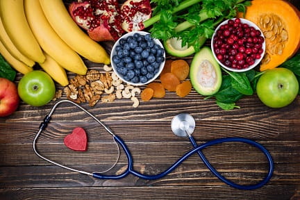 Variety of healthy heart foods and a stethoscope