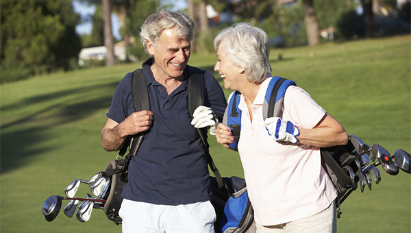 A senior couple is playing golf together in the summer.