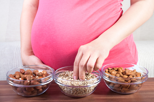 A pregnant woman is eating a healthy snack.