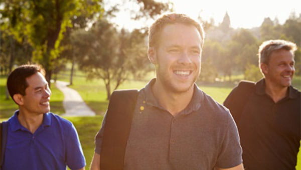 A group of male friends is walking outdoors.