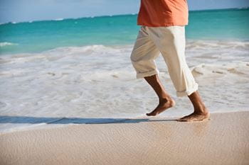 Man waking in the surf on the beach