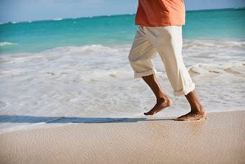 Man waking in the surf on the beach