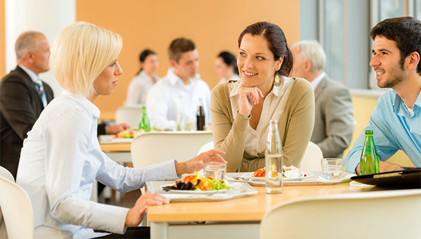 Three coworkers, two women and a man, have lunch together.