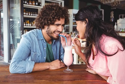 Young couple sharing a milkshake