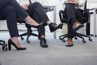 people sitting in office chairs with their legs crossed