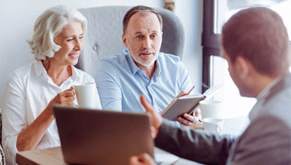 Elderly man and woman talking to an insurance agent