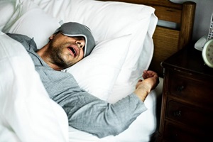 man sleeping wearing an eye mask