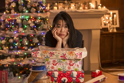 A woman is stressed out from holiday activities like decorating and wrapping gifts.