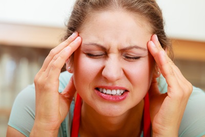 A woman has a migraine.