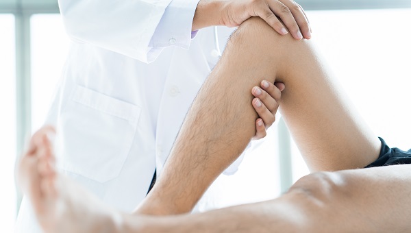 A doctor is examining a patient's knee.