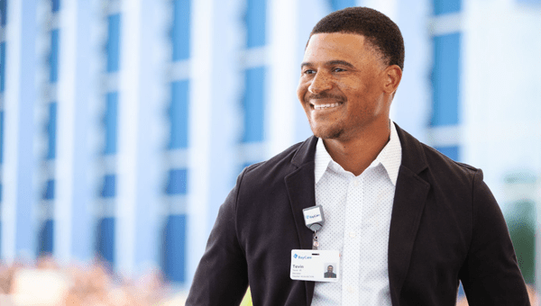 A male BayCare employee in a blazer smiling for a photo.