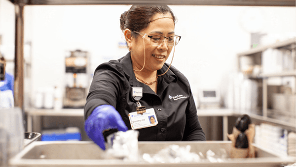 A female BayCare employee working in a lab setting.