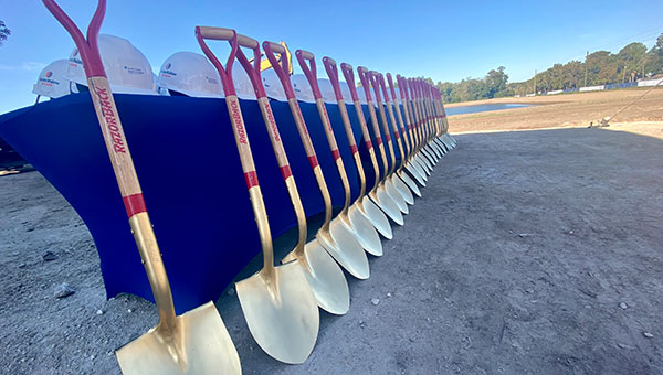 a line of shovels resting against a wall