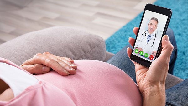 A pregnant woman is talking with a male doctor via video chat on her cellphone during a BayCareAnywhere telemedicine visit.