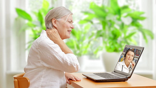 A woman is talking to a female doctor via video chat on her laptop during a BayCareAnywhere telemedicine visit.