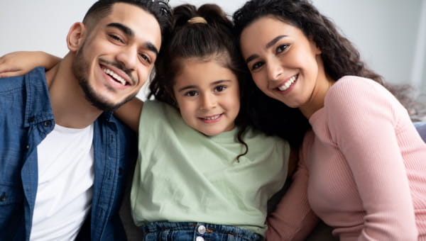 a young couple posing with their daughter in the middle