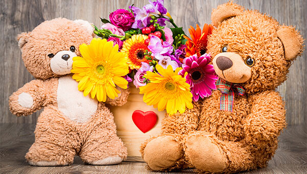 Two teddy bears and flowers