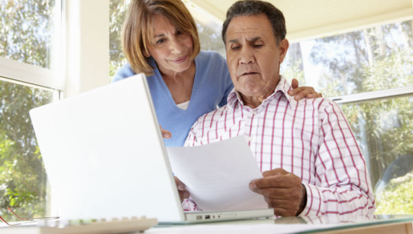 middle age man and woman looking at laptop