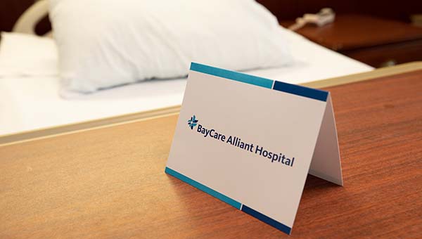 a folded card on a wooden desk that reads "BayCare Alliant Hospital"