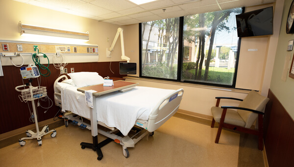 an empty hospital room with bed and medical equipment