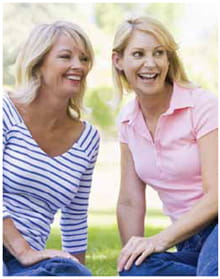 Two blonde women sitting outside