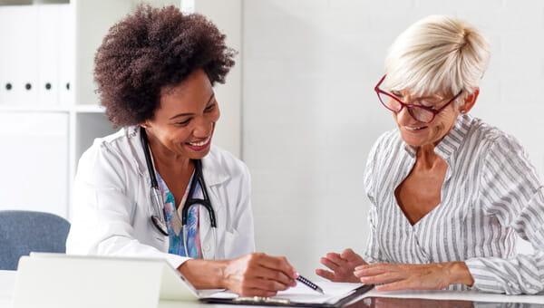 A nurse navigator is talking with a female patient.