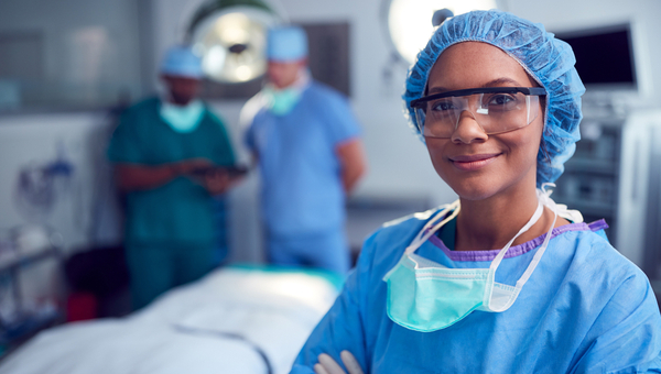 woman surgeon wearing scrubs and protective equipment