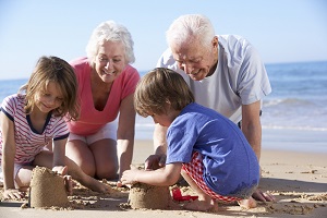 Grandparents enjoying a day at the beach with their grandchildren