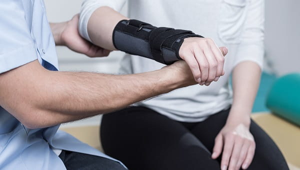 An occupational therapist is treating a patient's arm.